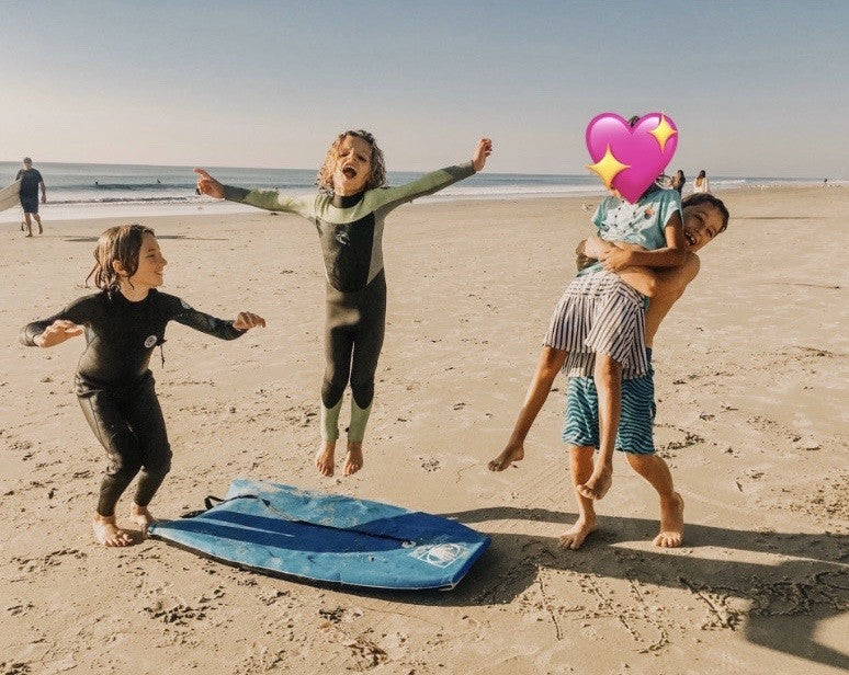 A picture of Grace* with our 3 boys having fun at the beach.